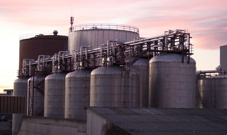 Crude oil storage tanks at dusk, illustrating oil imports and energy-market pricing