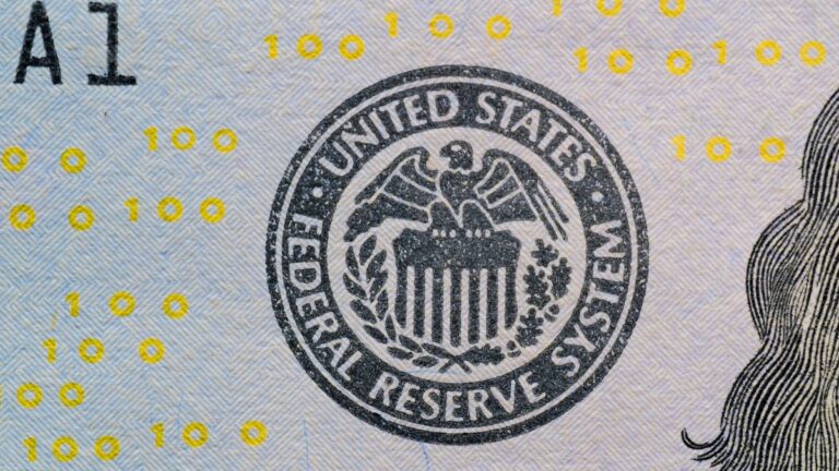 Close-up of the Federal Reserve System seal printed on a US hundred-dollar bill