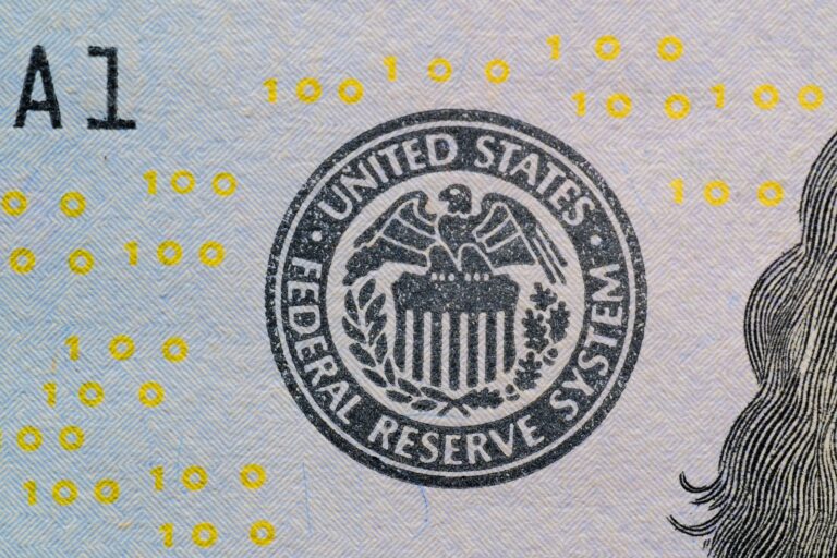 Close-up of the Federal Reserve System seal printed on a U.S. $100 bill